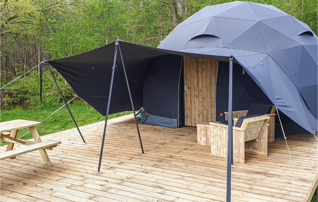 a blue tent on a wooden deck with a picnic table at Nice Stacaravan In Hoogersmilde in Hoogersmilde