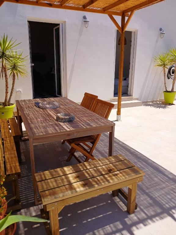 a wooden table and a bench on a patio at Casa Plemmirio Varco 22 in Plemmirio