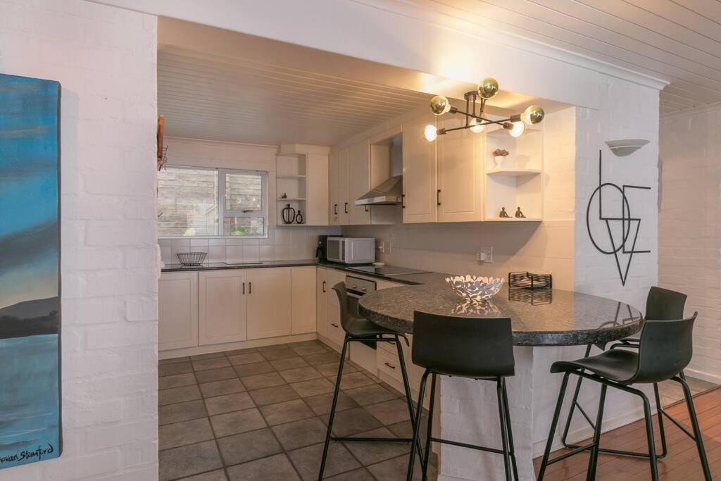 a kitchen with a table and chairs in a room at Herons House in Knysna