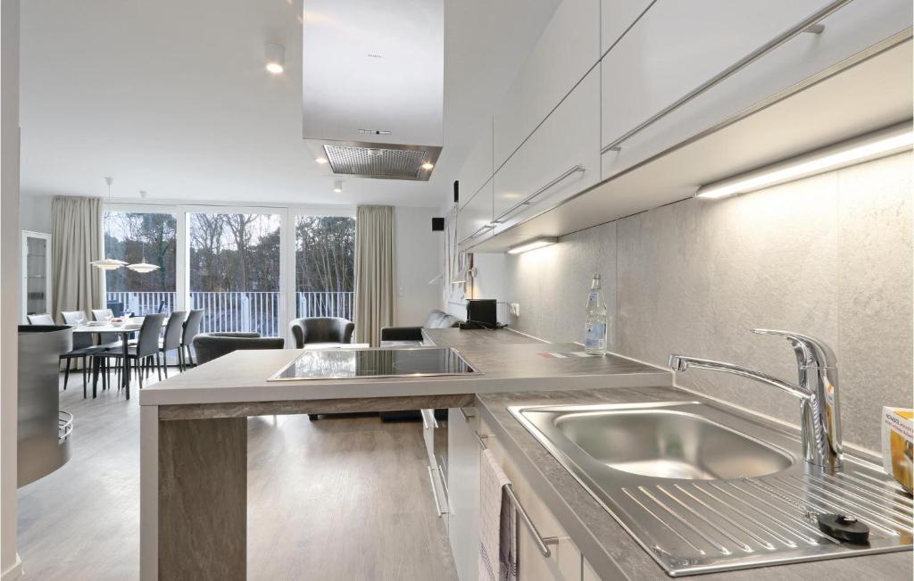 een keuken met 2 wastafels en een eetkamer bij Dünenvilla 6, Whg 1 in Travemünde