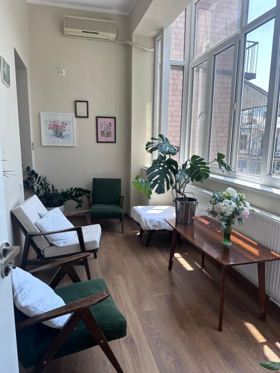 a living room with a table and chairs and windows at Feel at home chugureti in Tbilisi City