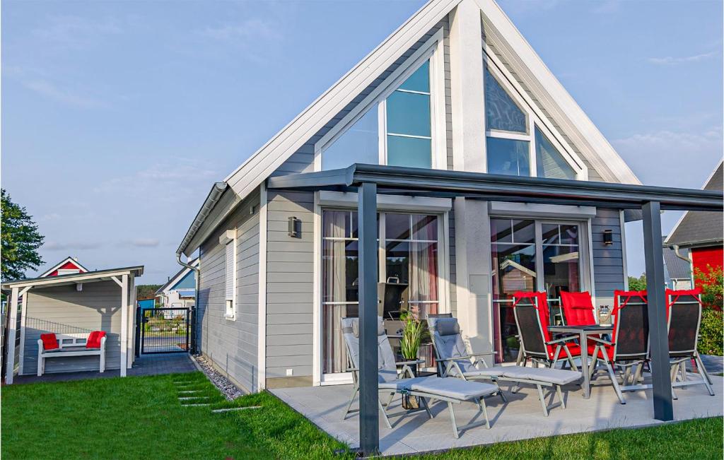 a small house with a deck with red chairs at Gorgeous Home In Zerpenschleuse in Zerpenschleuse