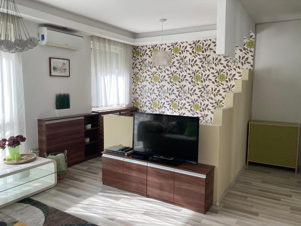 a living room with a flat screen tv on a wall at Comfy Camel Apartment in Budapest