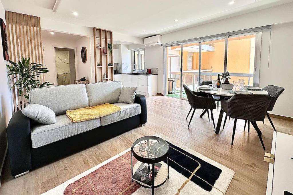 a living room with a couch and a table at Le Mediterranée-centre-climatisation in Menton