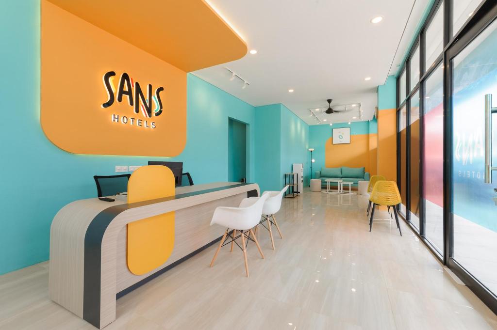 a sams hotel lobby with chairs and a counter at Sans Hotel Tajur Bogor in Bantarkamang