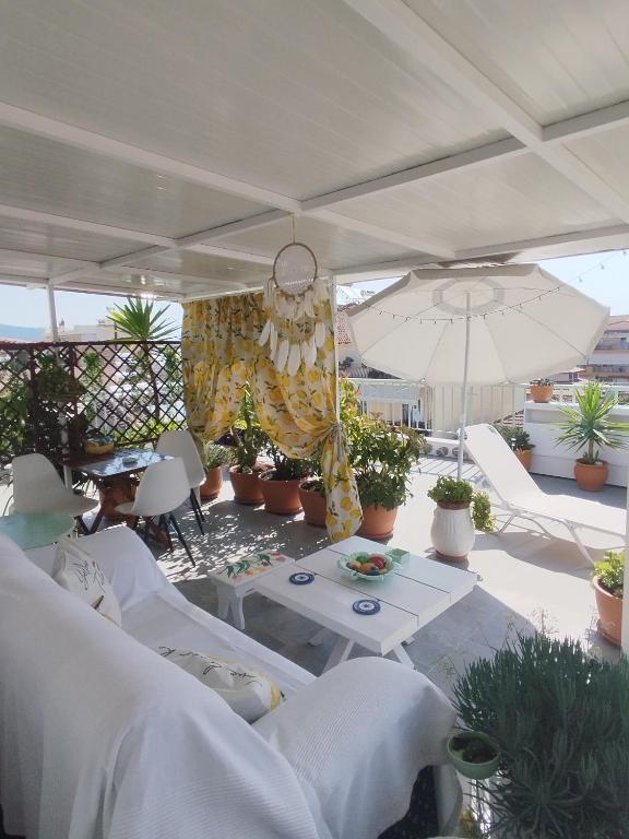 a patio with a table and an umbrella and plants at Suzy's nest room in Asprovalta