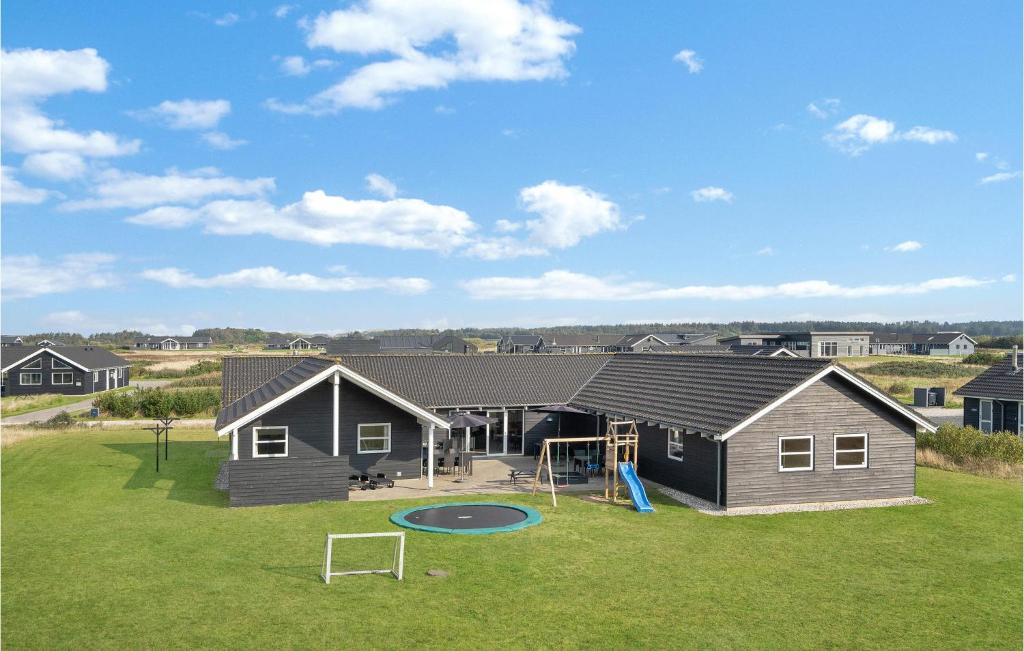 a house with a playground in the yard at Lovely Home In Løkken With Wifi in Løkken