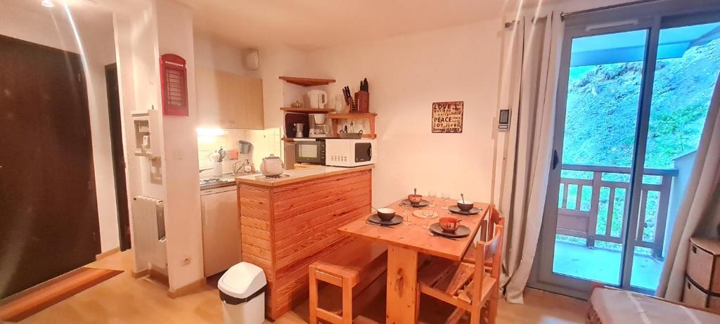 une cuisine avec une table en bois et une cuisine avec une fenêtre dans l'établissement EQUINOXE-203- Appt 4 pers Souplex, à Les Deux Alpes