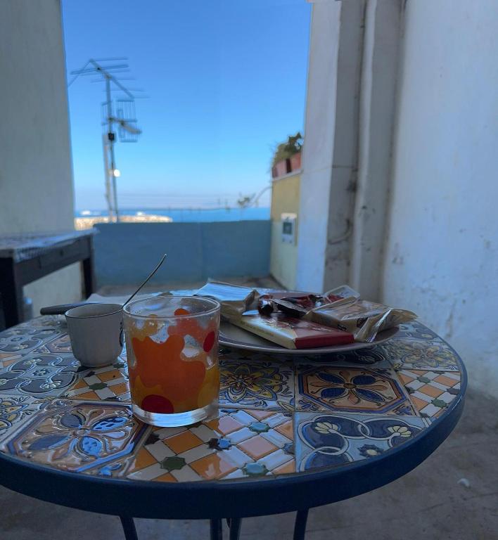 a table with a drink and a plate of food on it at On The Beach SORRENTO in Massa Lubrense