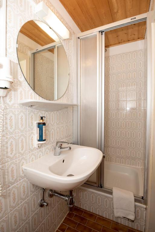 un bagno con lavandino e specchio di Hotel Alpen Arnika a Tauplitzalm