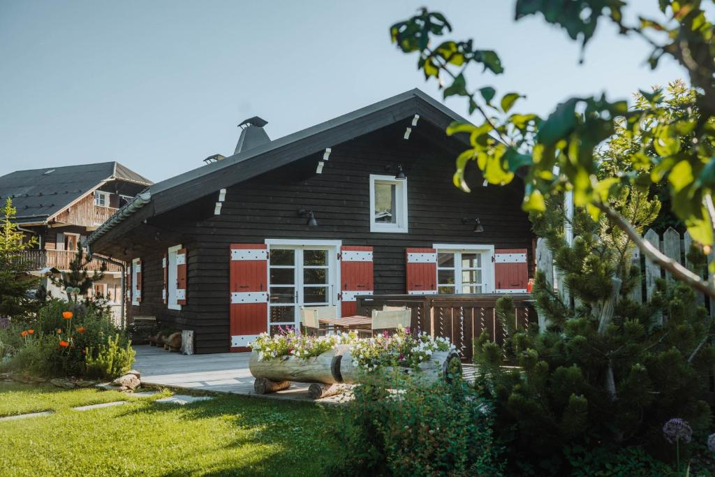 una casa nera con porte rosse e un cortile di Chalet du Skieur, avec services, Collection Chalets des Fermes a Megève
