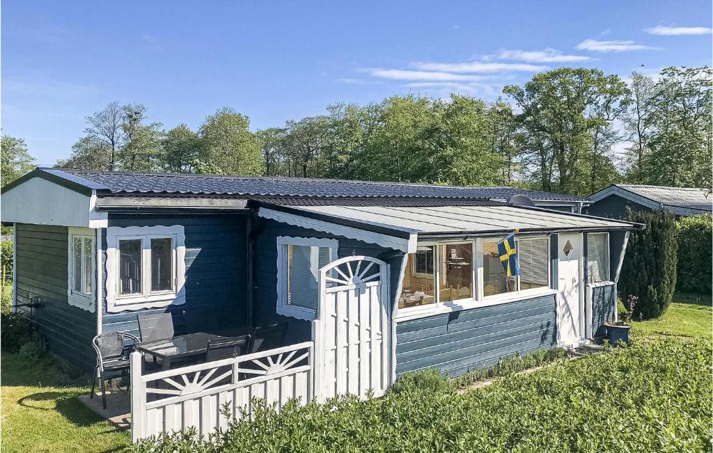 a blue house with a white door and a fence at Gorgeous Home In Hörby With Kitchen in Hörby