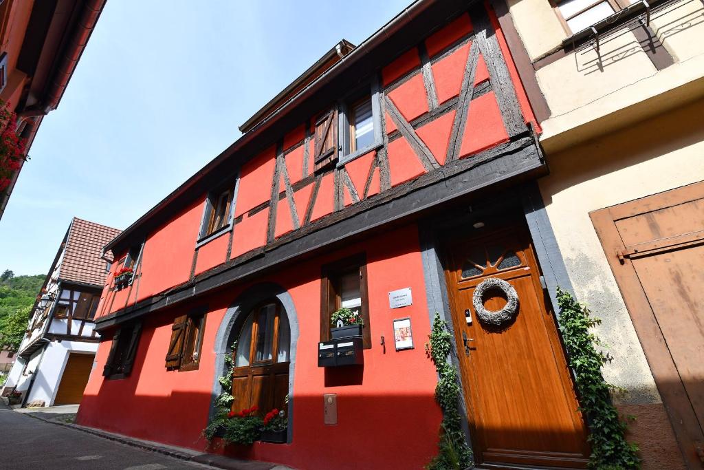 - un bâtiment rouge et blanc avec une porte en bois dans l'établissement Appartement Villa Joseph, à Kaysersberg