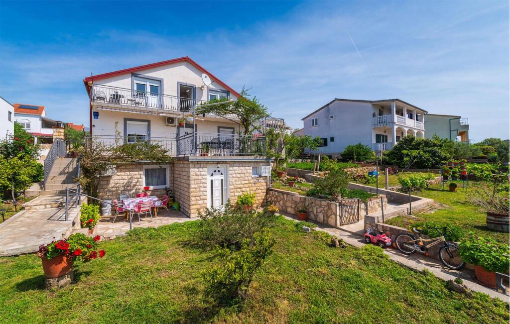 a house on top of a hill with a yard at 3 Bedroom Amazing Apartment In Jasenice in Jasenice
