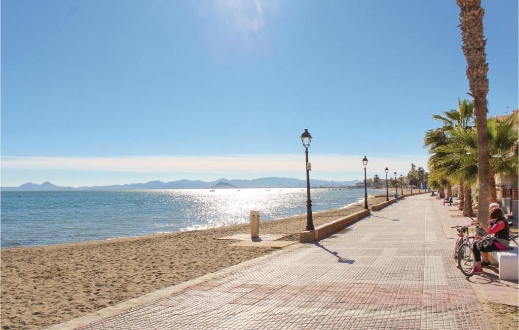 eine Person, die auf einem Fahrrad an einem Strand sitzt in der Unterkunft Cozy Apartment In Los Alcazares in Los Alcázares