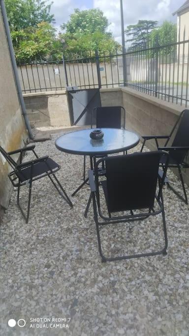 une table et des chaises sur un balcon avec une table et des chaises dans l'établissement charmante maison de bourg, à Francueil