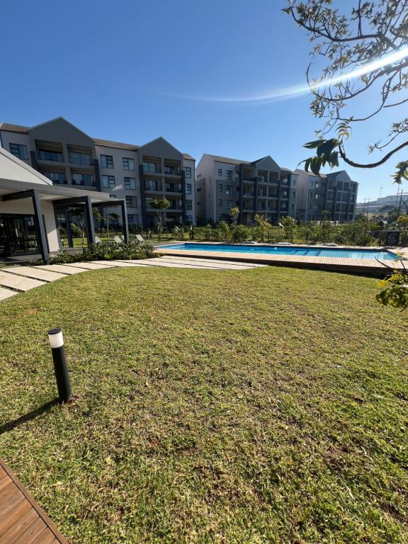 a large grassy yard with a building in the background at Ballito Village Suites in Ballito