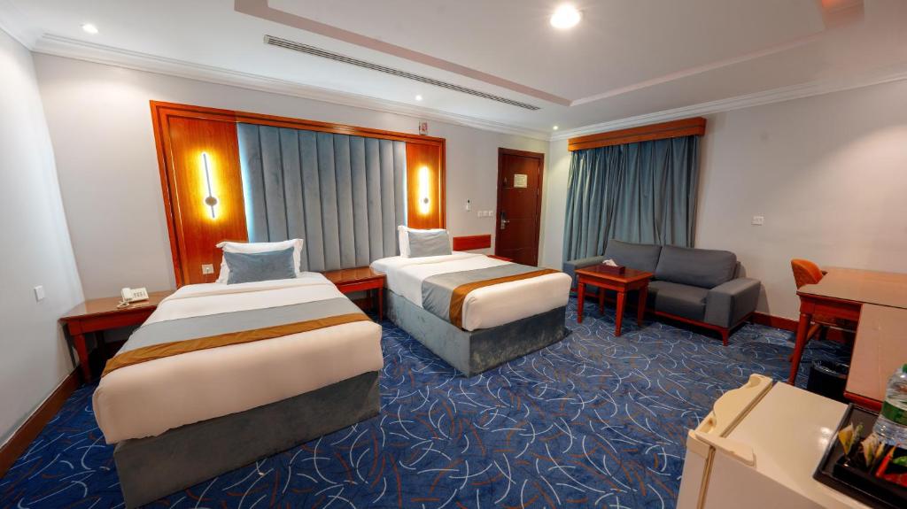 a hotel room with two beds and a couch at Al Masem Serviced Apartments - Gharnata - Exit 9 in Riyadh