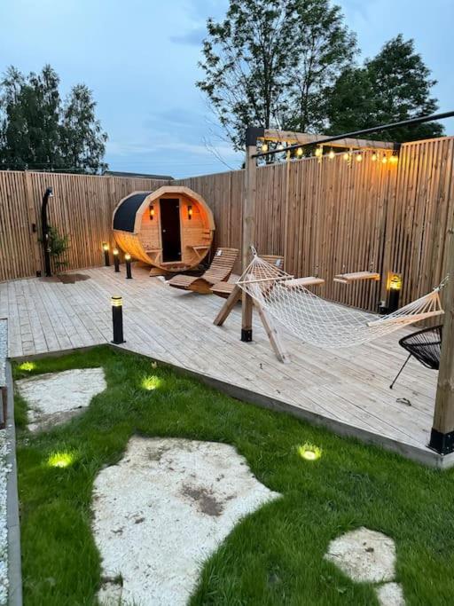 a backyard with a hammock and a wooden fence at Storm Cottage in the Countryside in Parczów