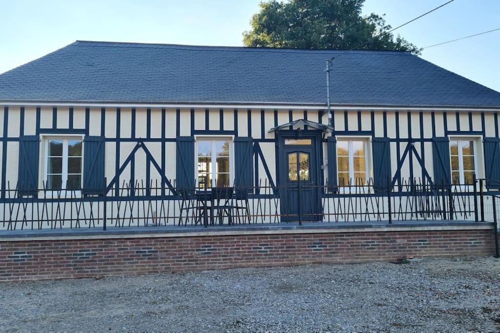 une maison en noir et blanc avec une clôture dans l'établissement Le Frêne Chantant, à Bazinval