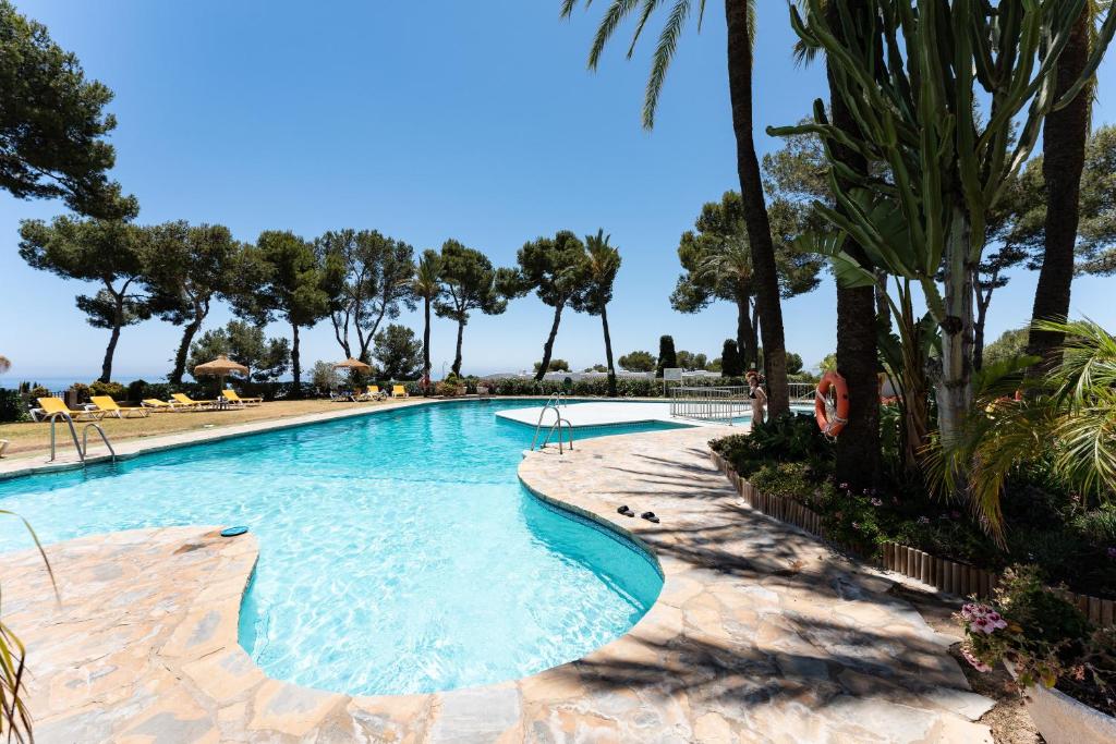 una piscina con palmeras en un resort en Parque Miraflores, en Mijas