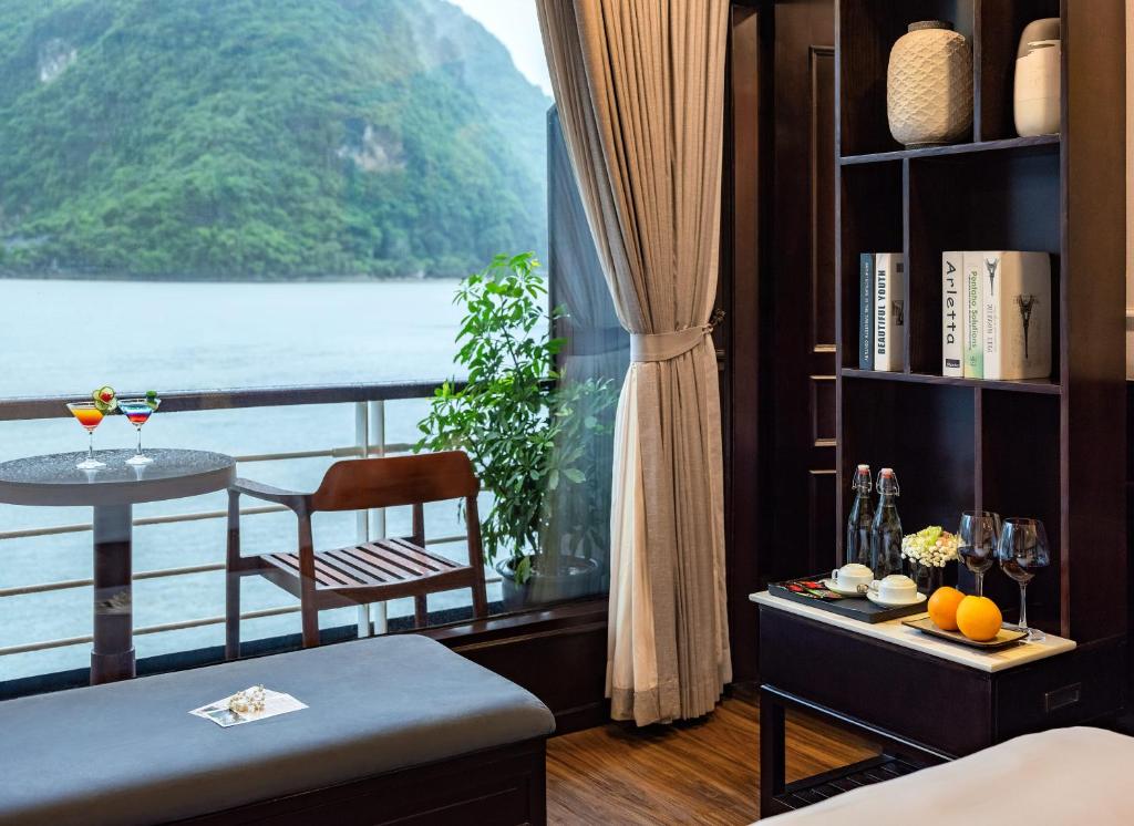 a room with a view of the ocean and a table at Amanda Luxury Cruise in Ha Long