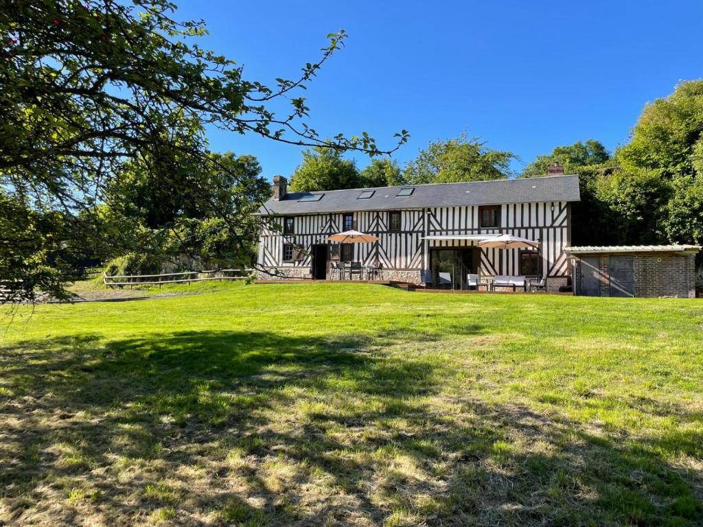 une vue extérieure d'une maison avec une grande cour dans l'établissement Charmante maison de campagne proche village, à Bonnebosq