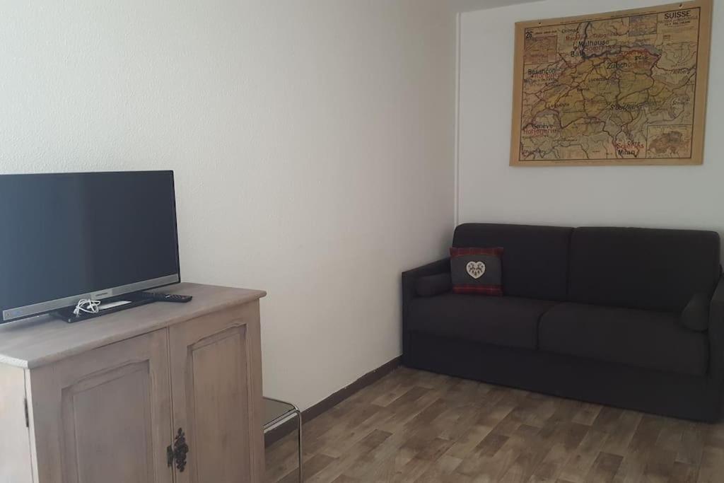 Una sala de estar con un sofá y un televisor de pantalla plana. en Studio city center, en Les Rousses