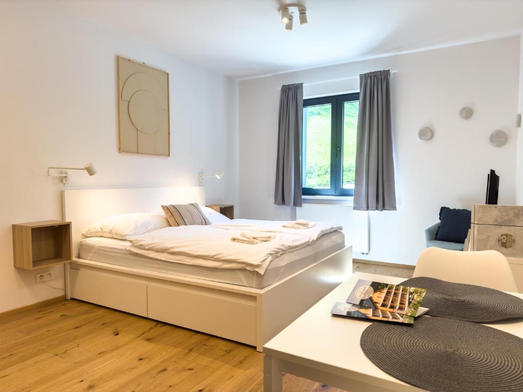 ein weißes Schlafzimmer mit einem Bett und einem Tisch in der Unterkunft Ski&Bike Apartmán Blue in Janské Lázně