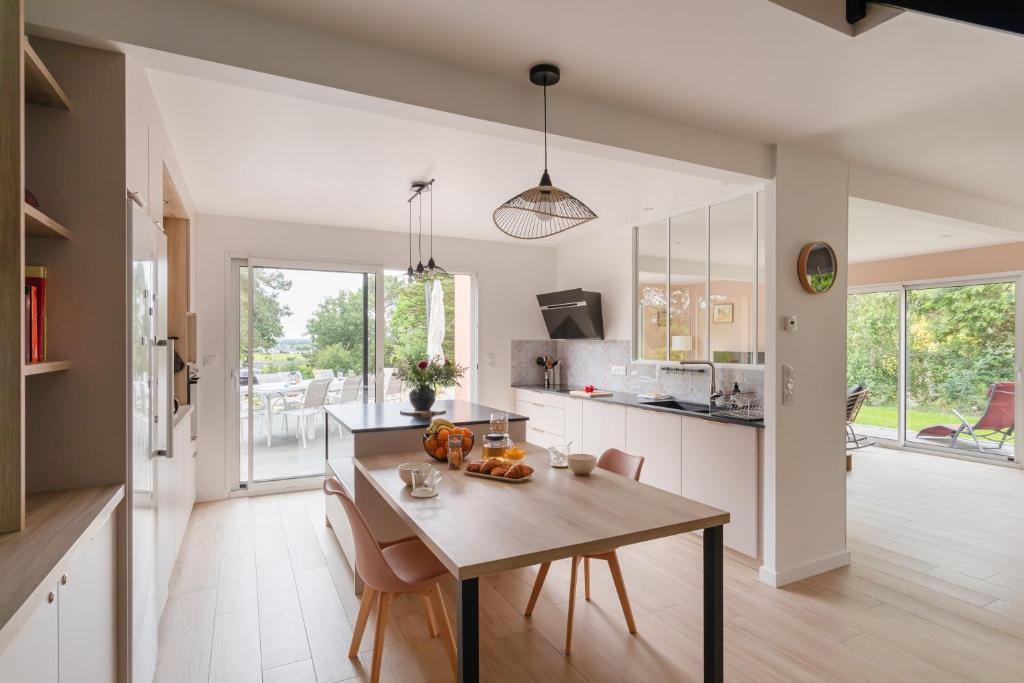 une cuisine avec une table et une salle à manger dans l'établissement Ty Fao - Maison pour 10 à Erquy, à Erquy