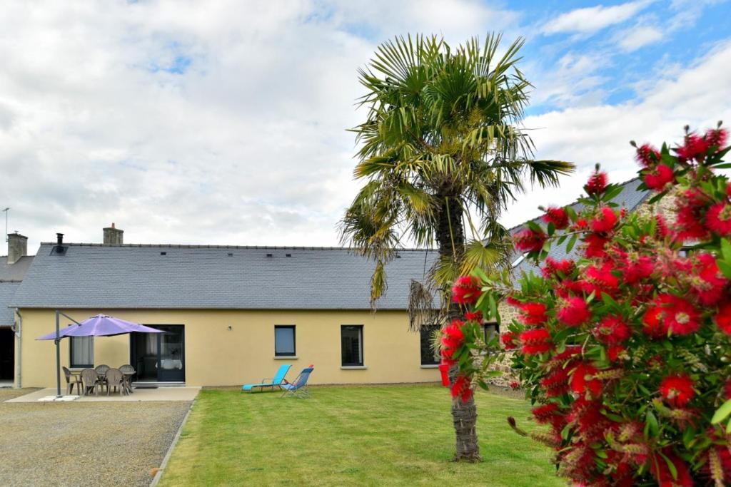 a house with a palm tree in front of it at Grande maison tout confort pour 4 personnes à Dol-de-Bretagne dans la Baie du-Mont-Saint-Michel in Dol-de-Bretagne