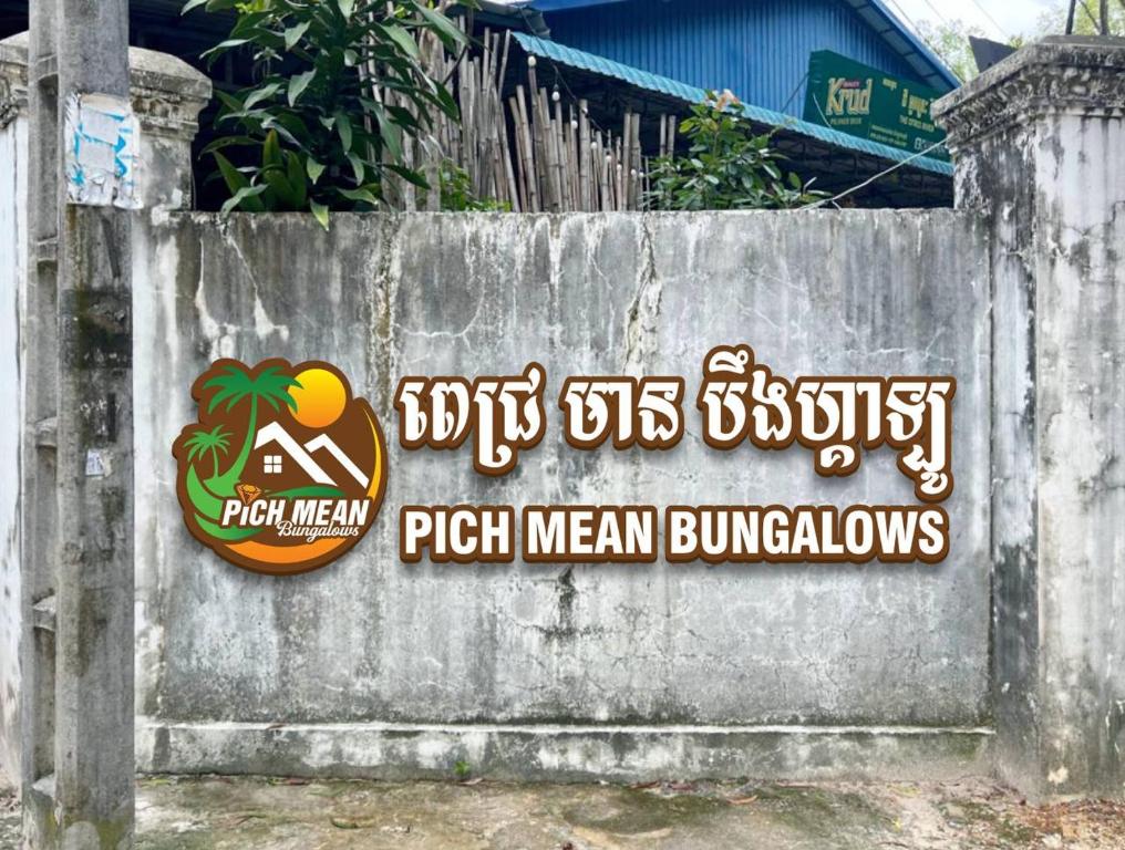 a sign on the side of a concrete wall at Pich Mean Bungalow in Sihanoukville