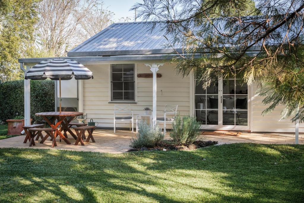 a house with a picnic table and an umbrella at Parker Cottage in Maleny
