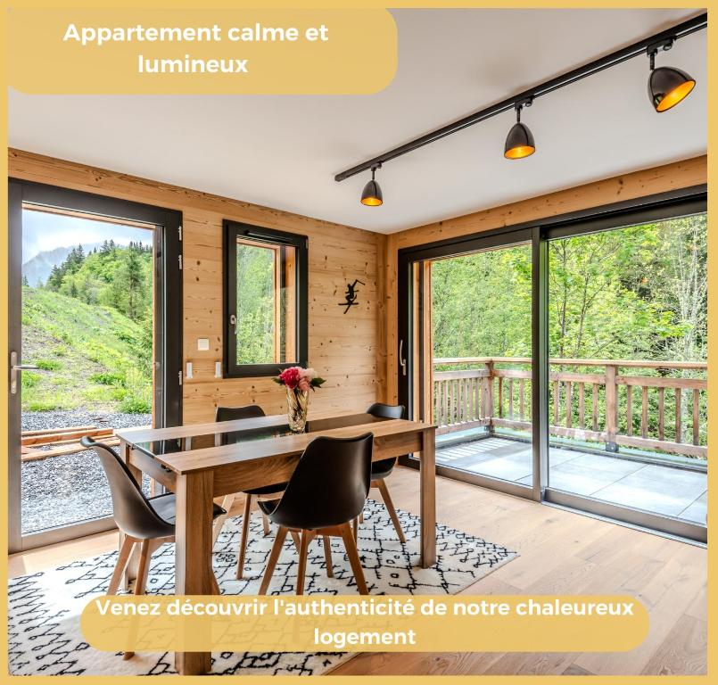 ein Esszimmer mit Tisch und Stühlen und Fenstern in der Unterkunft Le Solaris I Morzine in Morzine
