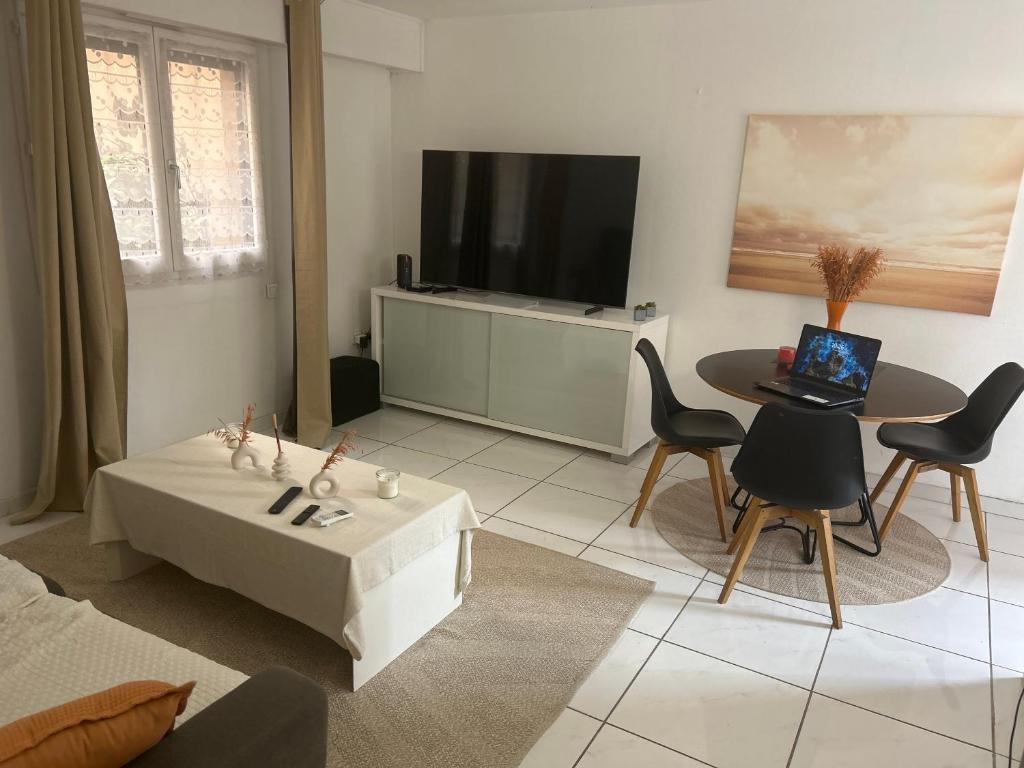 un salon avec une table et une télévision dans l'établissement Appartement spacieux climatisé piscines, à Cannes