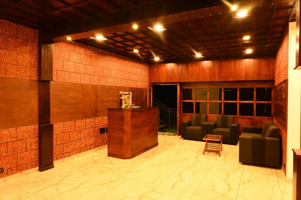 a lobby with chairs and a bar in a building at Elettaria Valley in Devikolam