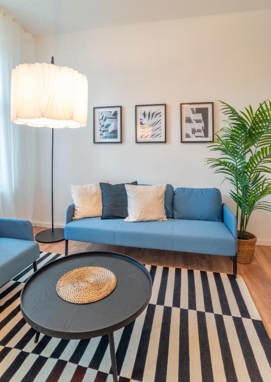 a living room with a blue couch and a table at Arbio Monteurzimmer Fredersdorf parking included in Altlandsberg-Süd