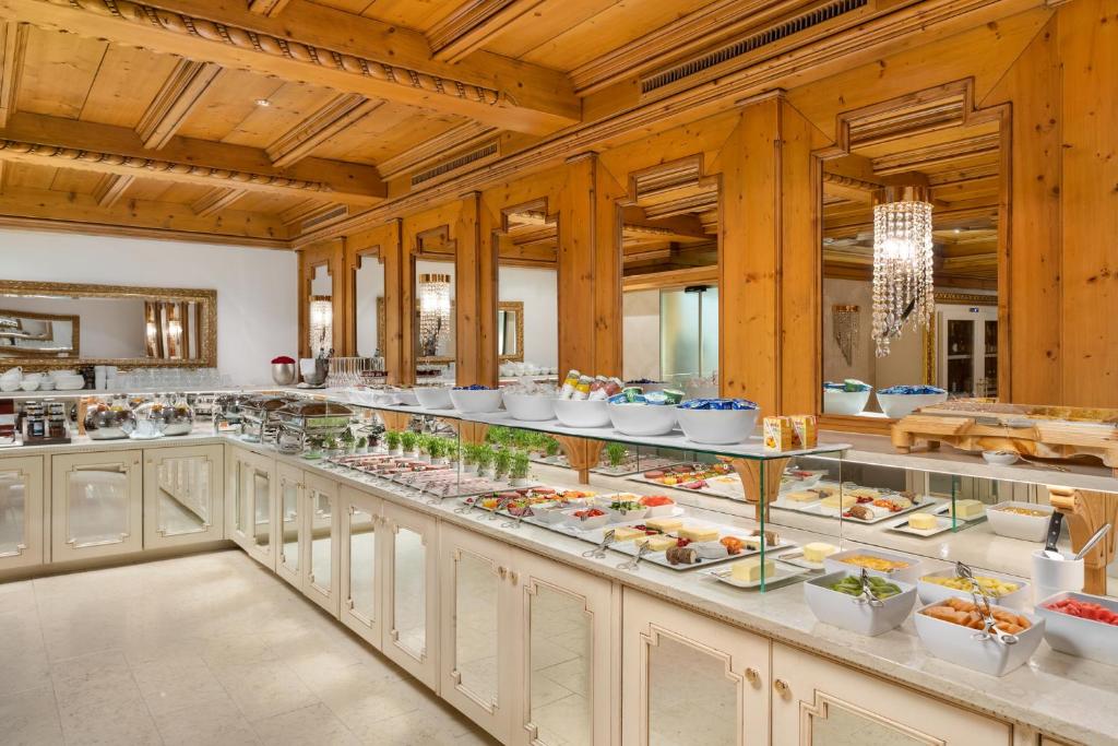 a buffet line with plates of food on display at Schlosshotel Ischgl 5-Sterne Superior in Ischgl