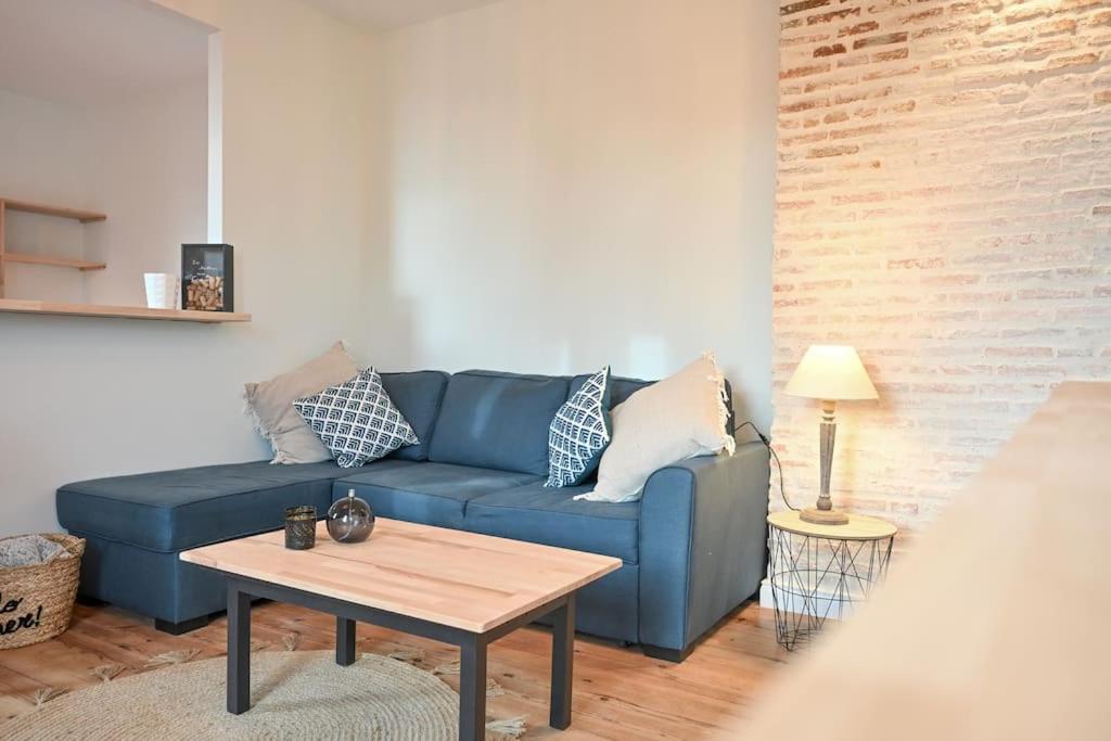 un salon avec un canapé bleu et une table dans l'établissement Bel appartement hyper centre, à Angers