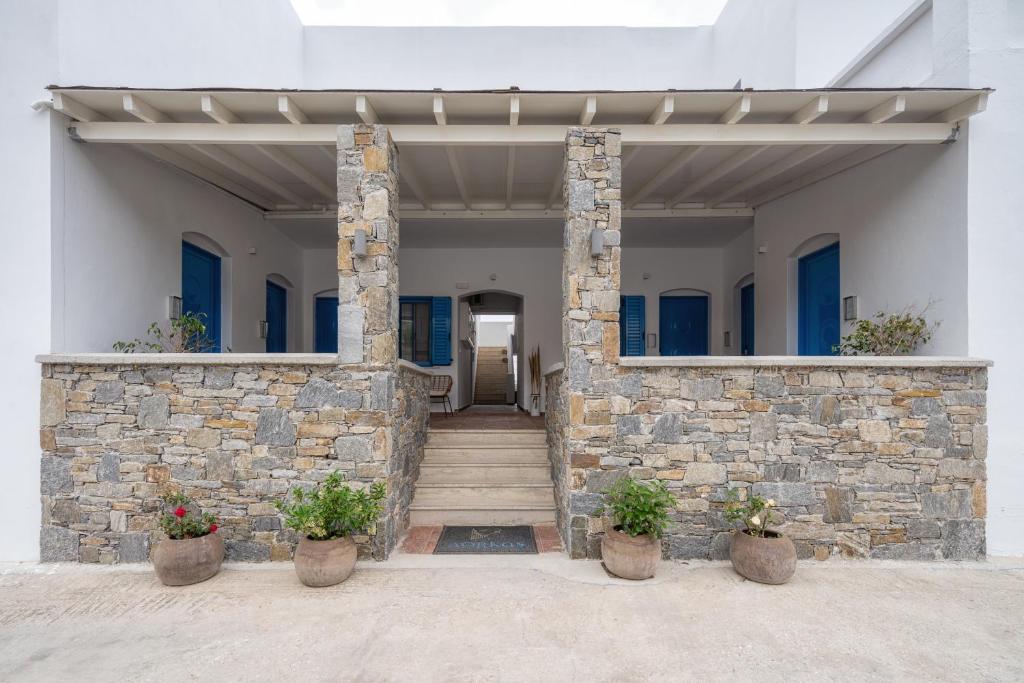 a stone building with stairs and potted plants at Dorkas Luxury Rooms&Apartments in Livadakia