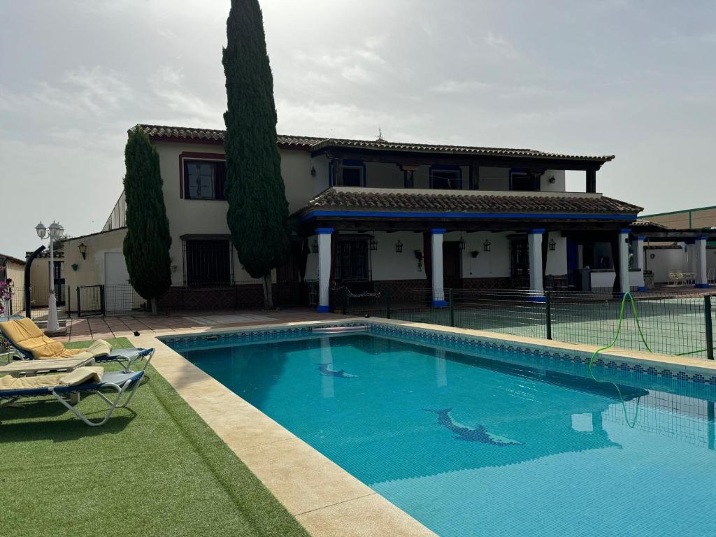 a swimming pool in front of a house at Hacienda el chorlo II in Encinarejo De Córdoba