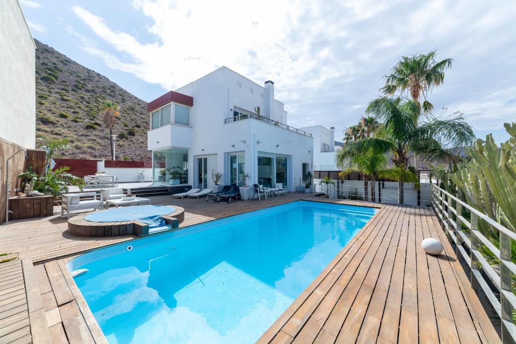 a house with a swimming pool and a wooden deck at Villa Lux in Níjar