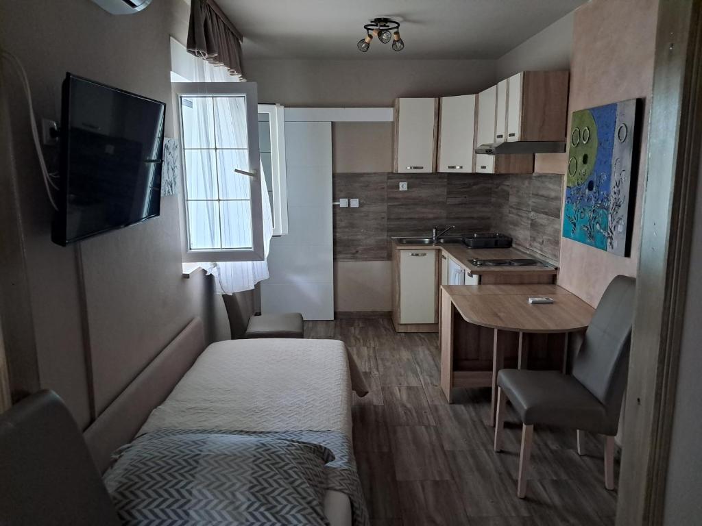 a small room with a bed and a small kitchen at Apartments Peričić in Podstrana