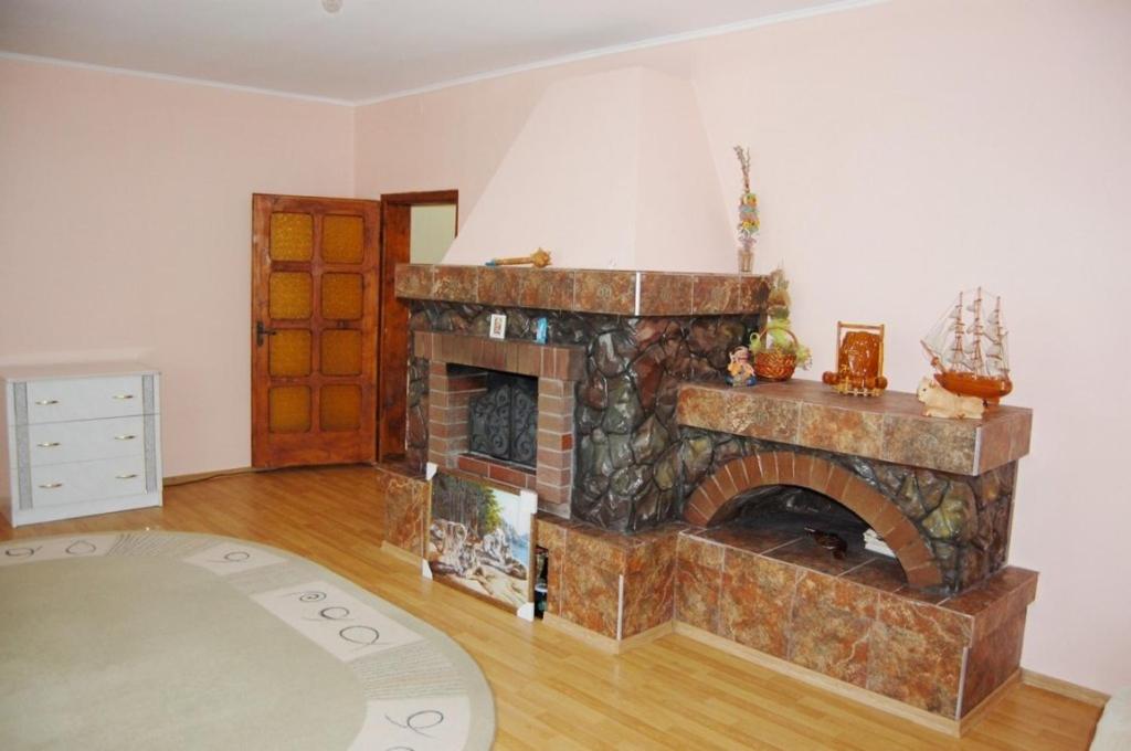 uma sala de estar com lareira de pedra num quarto em Merydian em Yasinia
