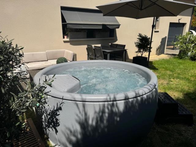 - un bain à remous dans une cour avec un parasol dans l'établissement ANNEXE du LAC, au Bourget-du-Lac