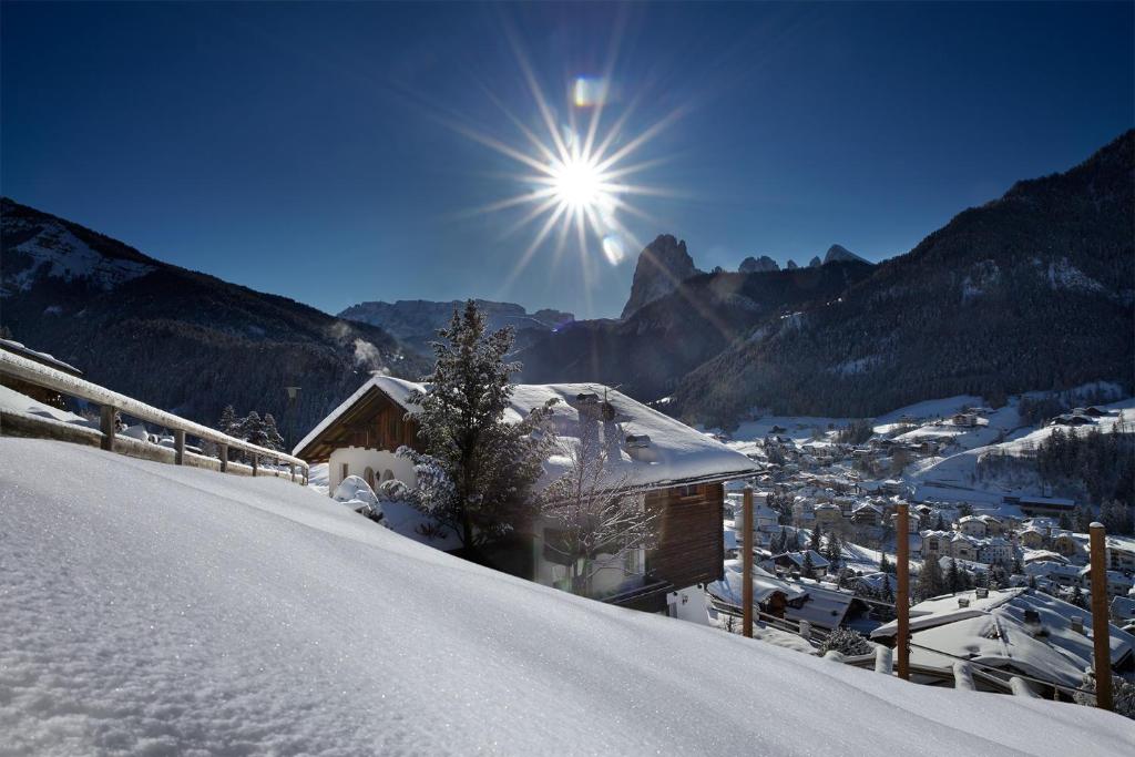 a snow covered mountain with a view of a city at Cësa Marmolada 1318 in Ortisei