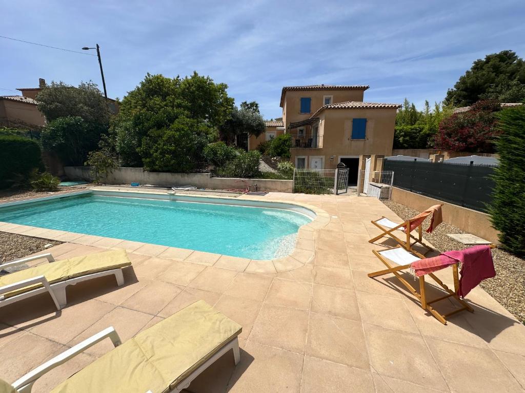 une piscine avec des chaises et une maison dans l'établissement Villa Lantana - 8 couchages - Plages et port à pieds, à Six-Fours-les-Plages