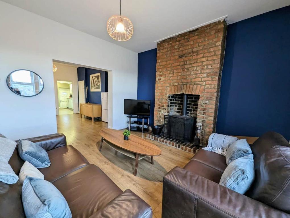 ゲーツヘッドにあるEnjoy 5 Br House Near The Cityのソファと暖炉のあるリビングルーム