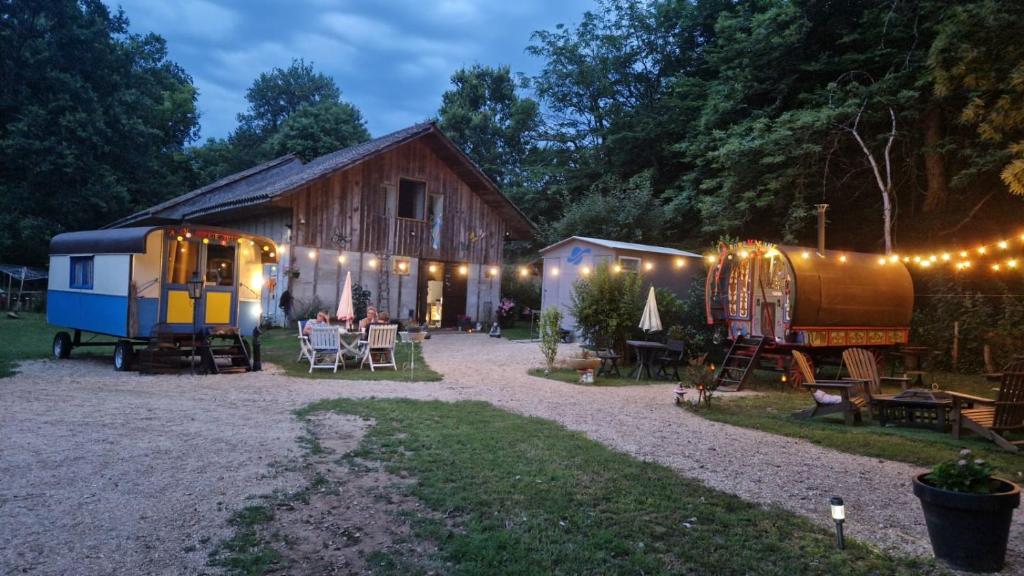 Git'an Périgord la Bonne aventure في Groléjac: حظيرة بها طاولة وكراسي وخيمة