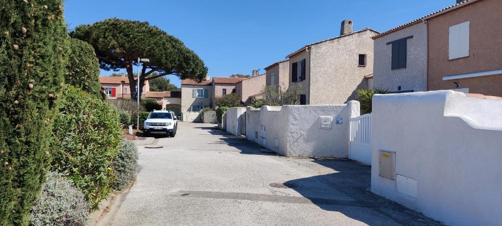 Une voiture descendant dans une rue à côté d'une clôture blanche dans l'établissement Villa Six-Fours Les Plages, à Six-Fours-les-Plages